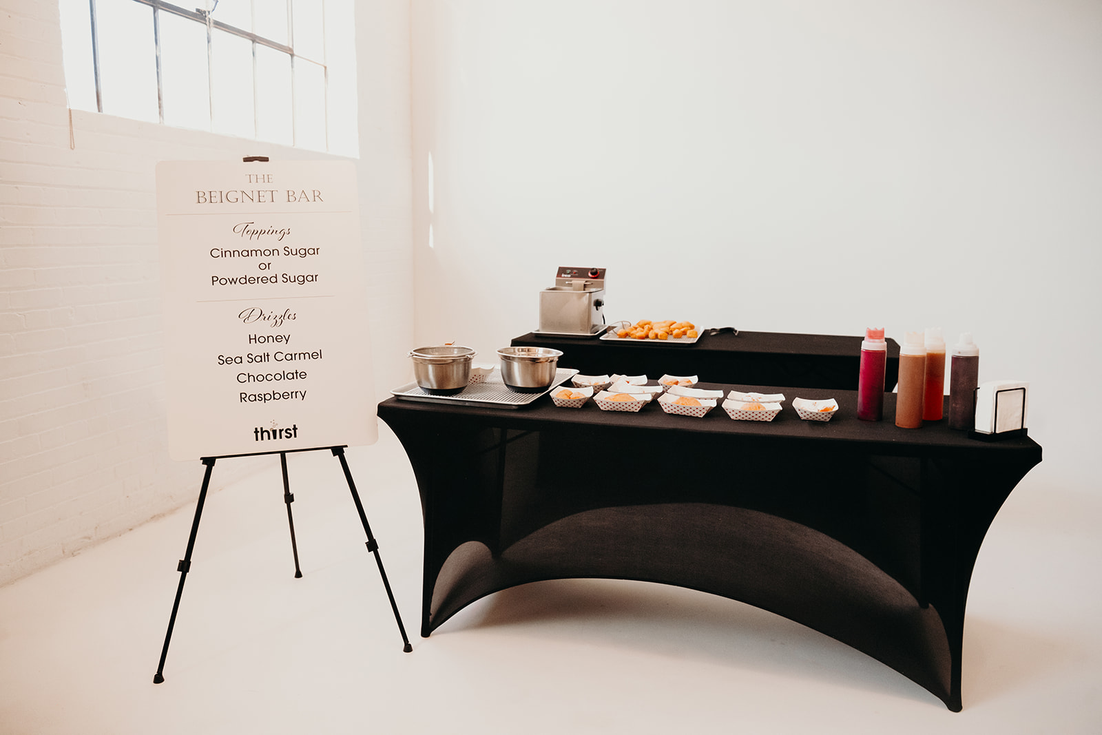 The Thirst Beignet Bar setup with fryer, toppings, and drizzles