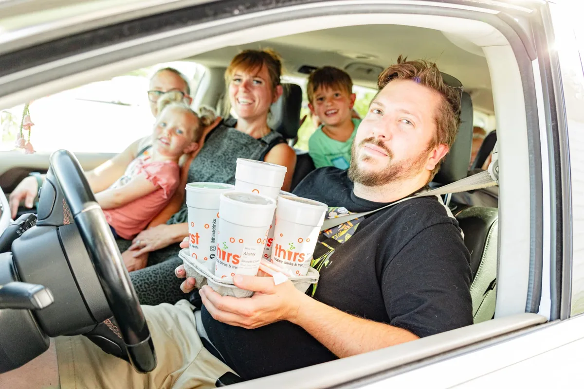Family in the drive-thru with a carrier of Thirst drinks