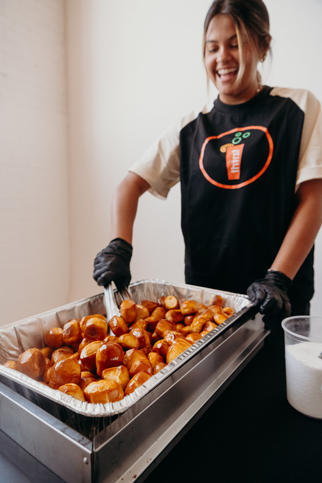 A Thirst team member serving warm pretzel bites from a catering tray